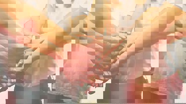 Billede af mange hænder som mødes i midten.