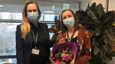 Lena Kristensne og Maria fra Aleris står med blomster i hænderne.