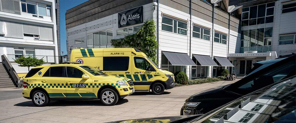 Ambulance holder foran bygning.