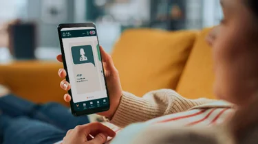 Patient sidder og snakker med læge fra Aleris online.