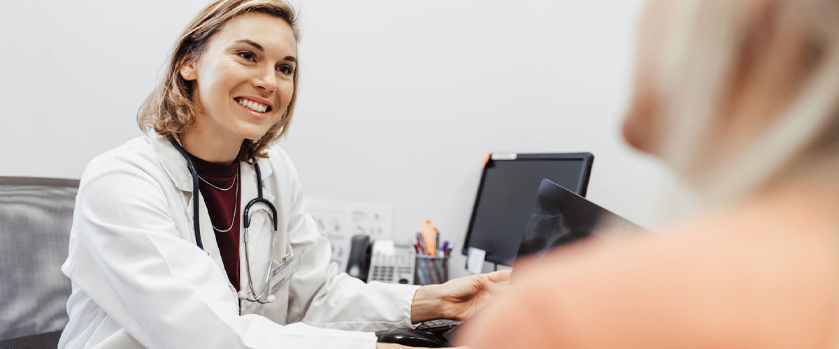 Læge smiler til sin patient.