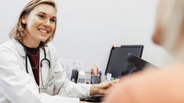 Læge smiler til sin patient.