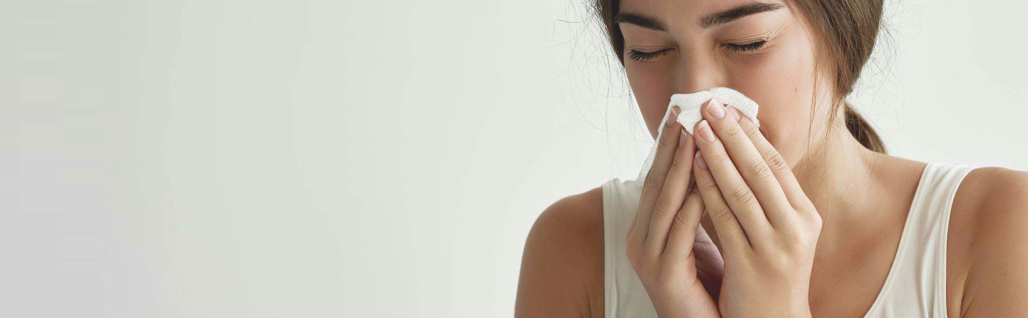 En kvinde med allergi pudser sin næse.