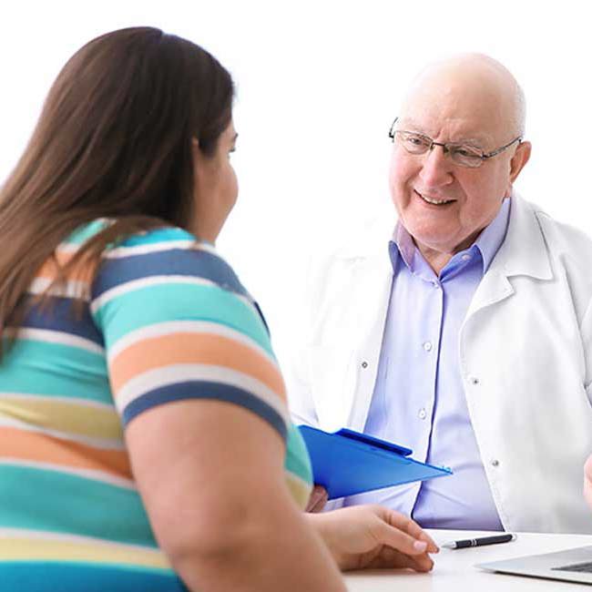 Læge snakker med patient om slidgigt ved vægttab.