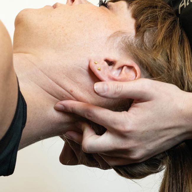 Fysioterapeut fra Aleris løsner patients hoved-nakke-smerter.