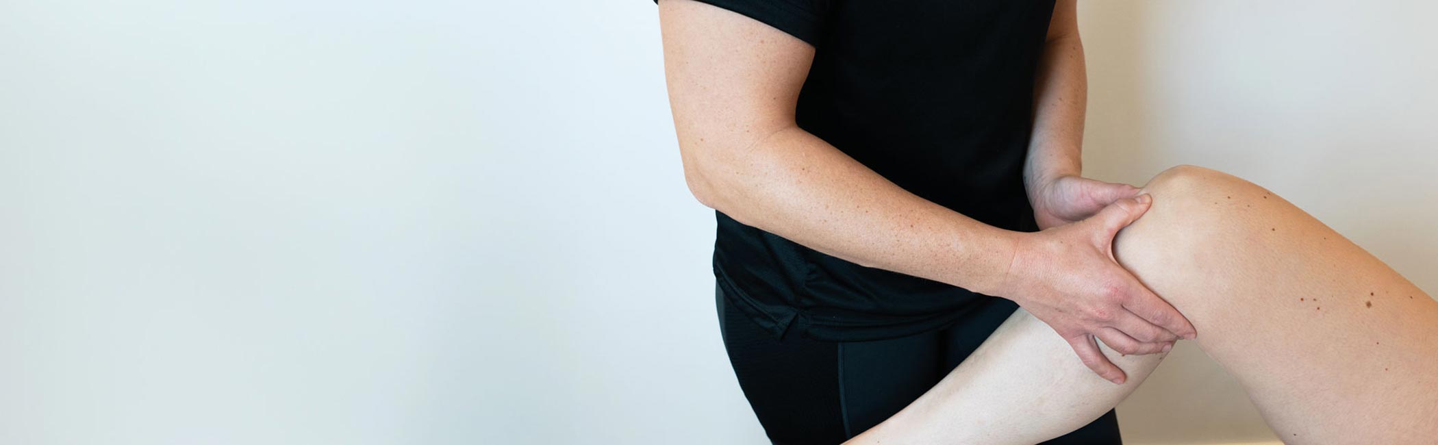 Fysioterapeut fra Aleris laver øvelser med patients knæ.