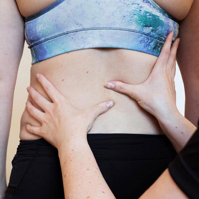 Aleris fysioterapeut mærker patient på ryggen.