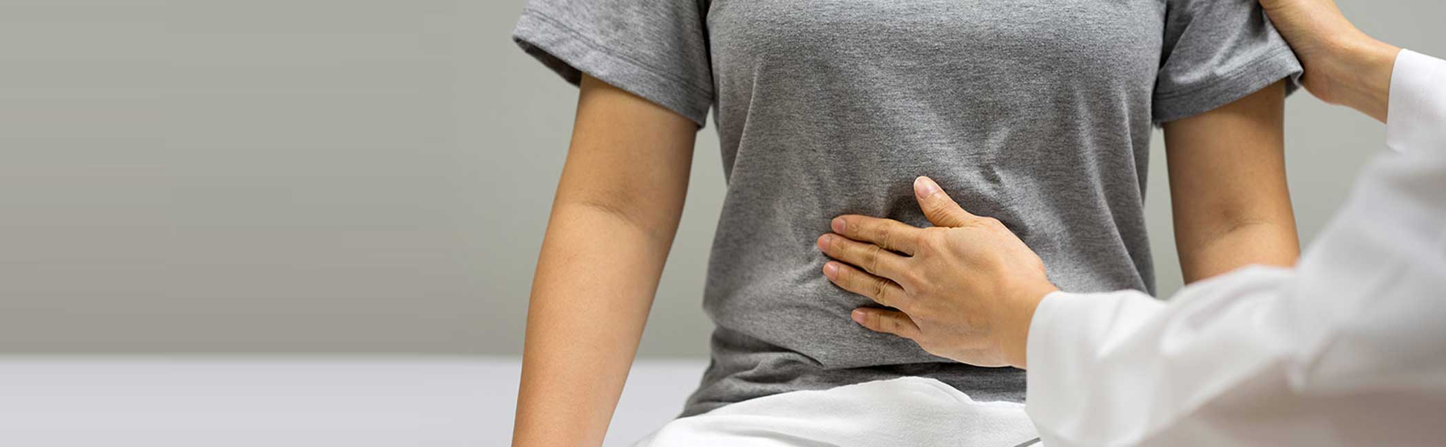 Læge mærker kvinde på maven.