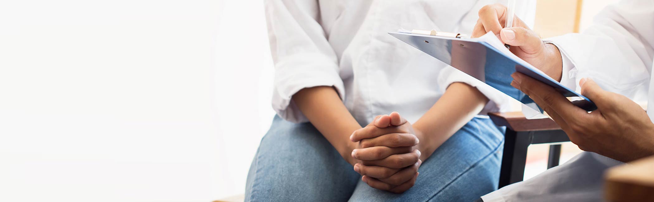 Kvinde sidder hos lægen.