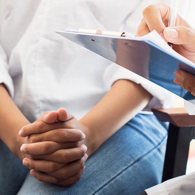 Kvinde sidder hos lægen.