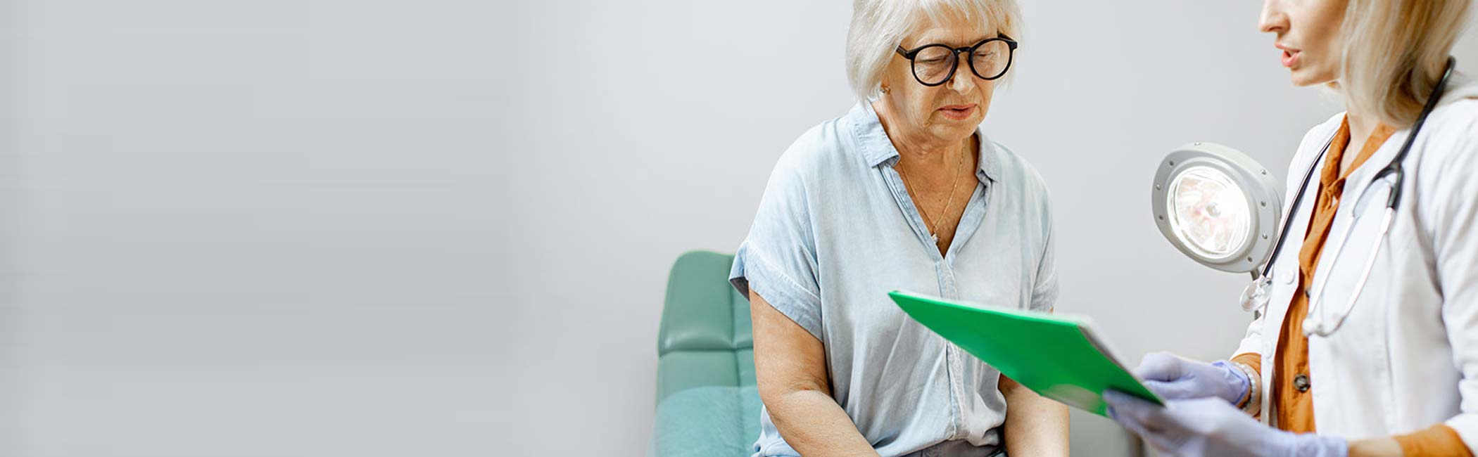 Patient og ældre kvinde sidder under en konsultation.