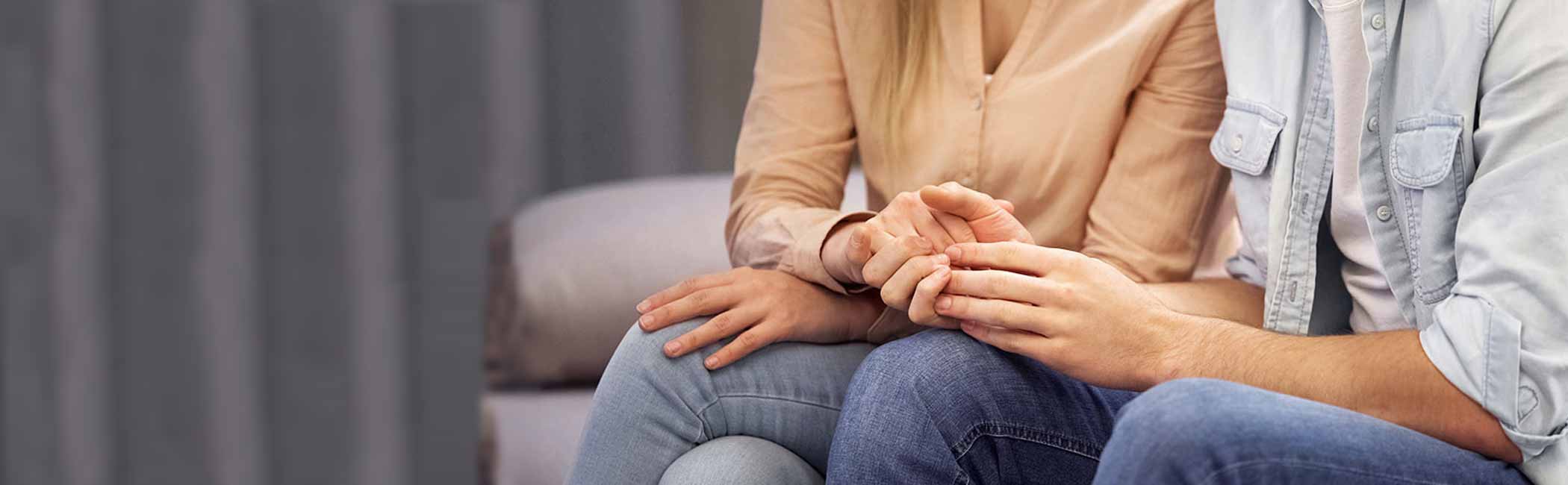 Et par sider og holder hinanden i hænderne.