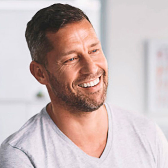 Læge taler med yngre mandlig patient til en konsultation.