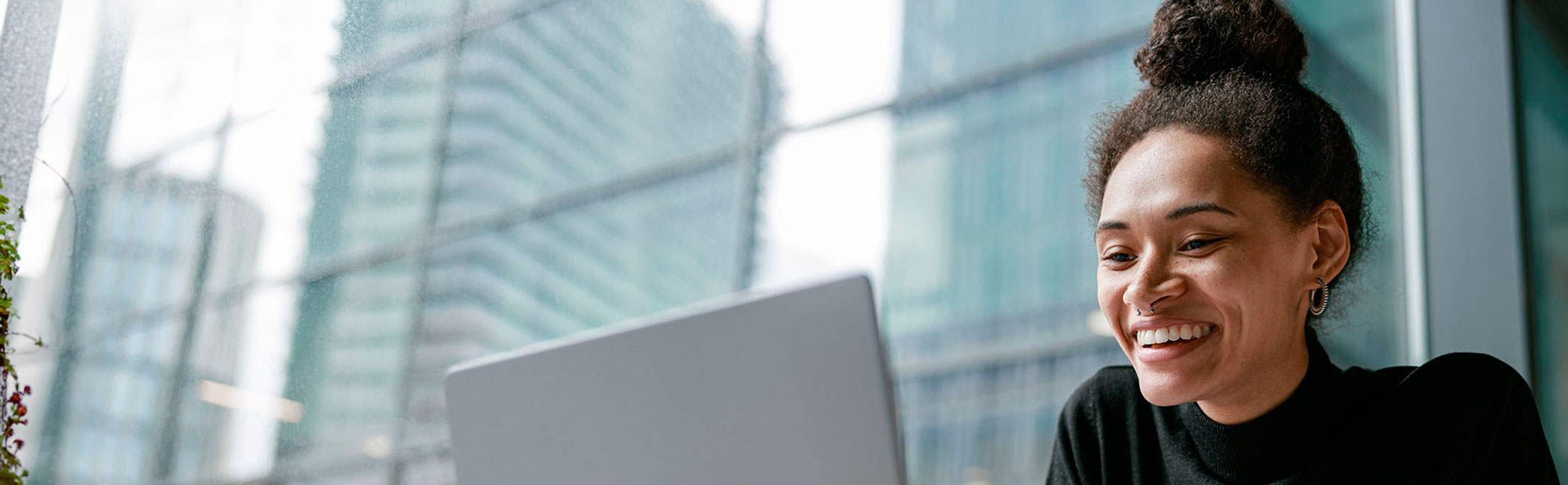 Smilende kvinde har en online samtale på en computer.