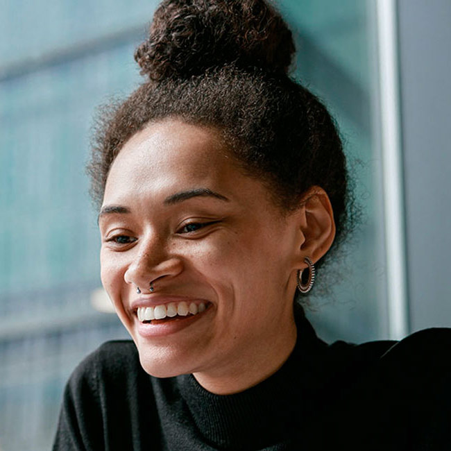 Smilende kvinde har en online samtale på en computer.