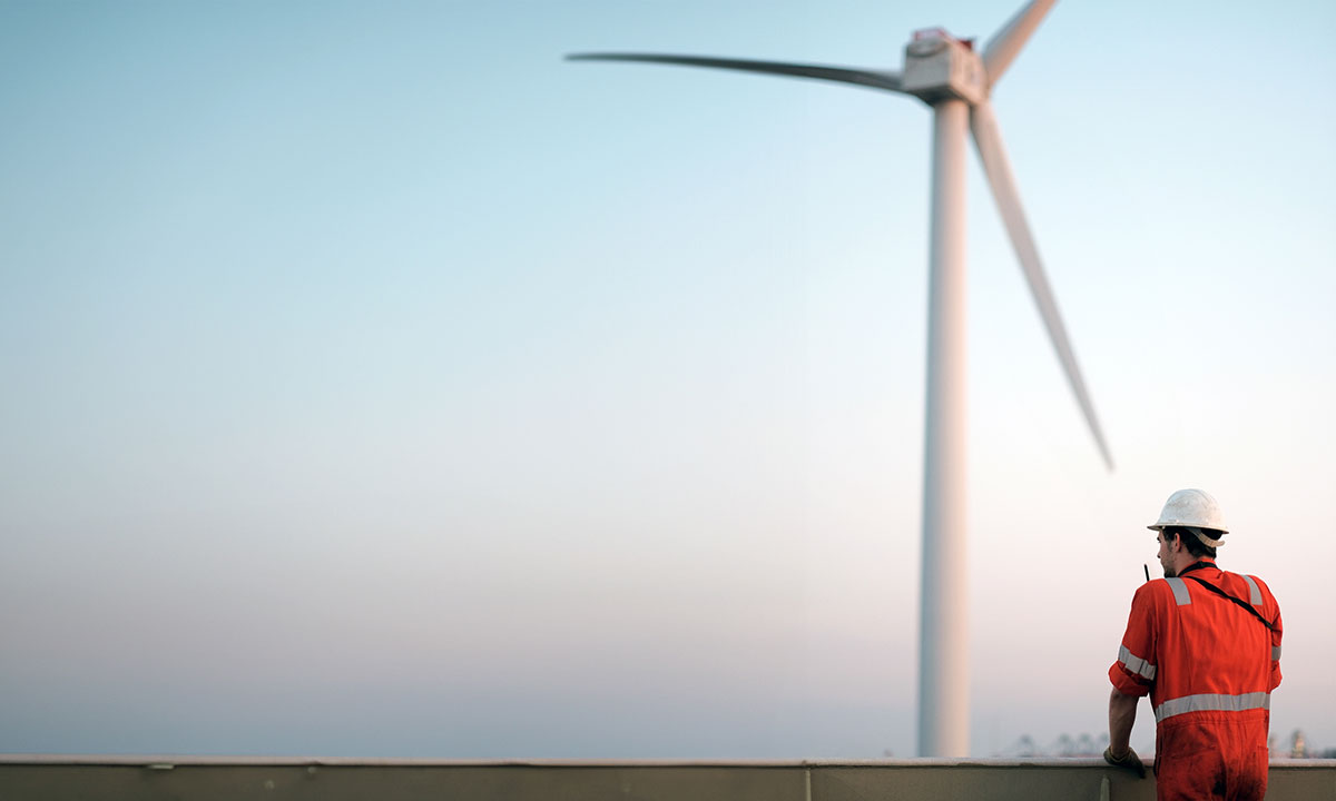 Mand står og kigger ud på vindmøller.