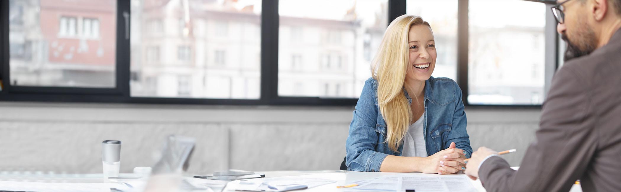 Smilende kvinde sidder til en konsultation hos en erhvervspsykolog.