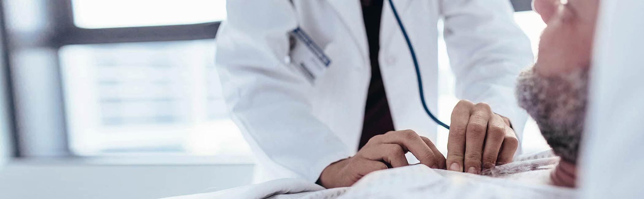 Læge og patient smiler til hinanden.