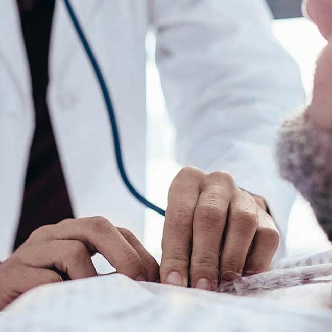 Læge og patient smiler til hinanden.