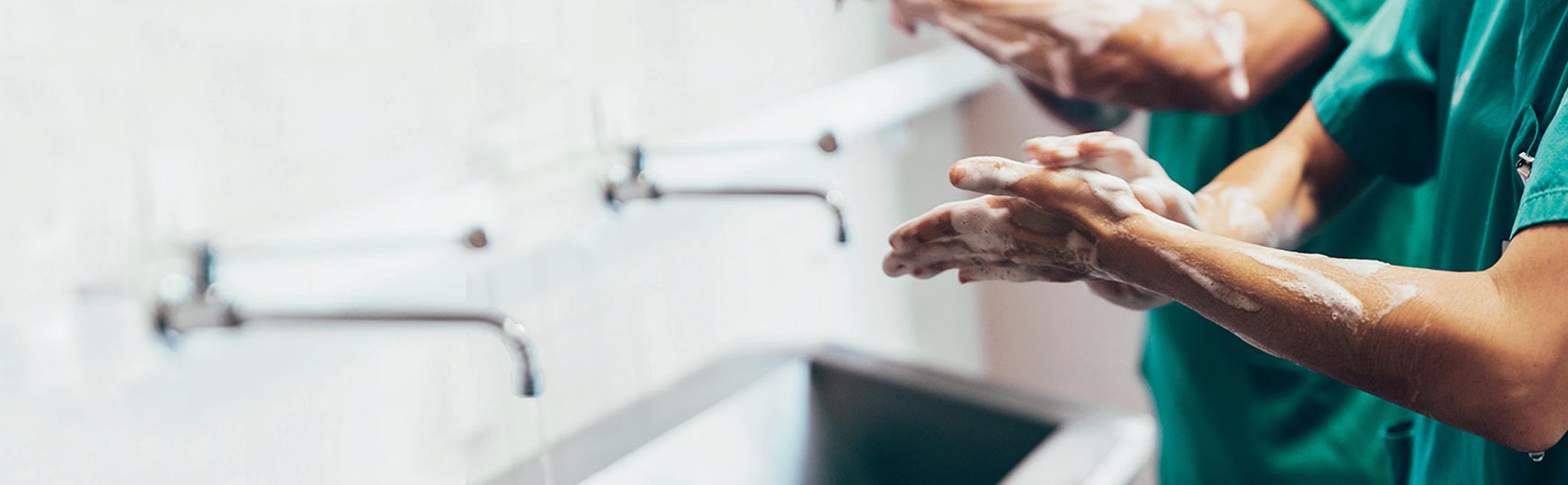 Læge vasker grundigt sine hænder inden operationen skal igang.