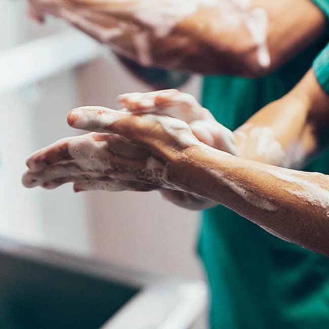 Læge vasker grundigt sine hænder inden operationen skal igang.