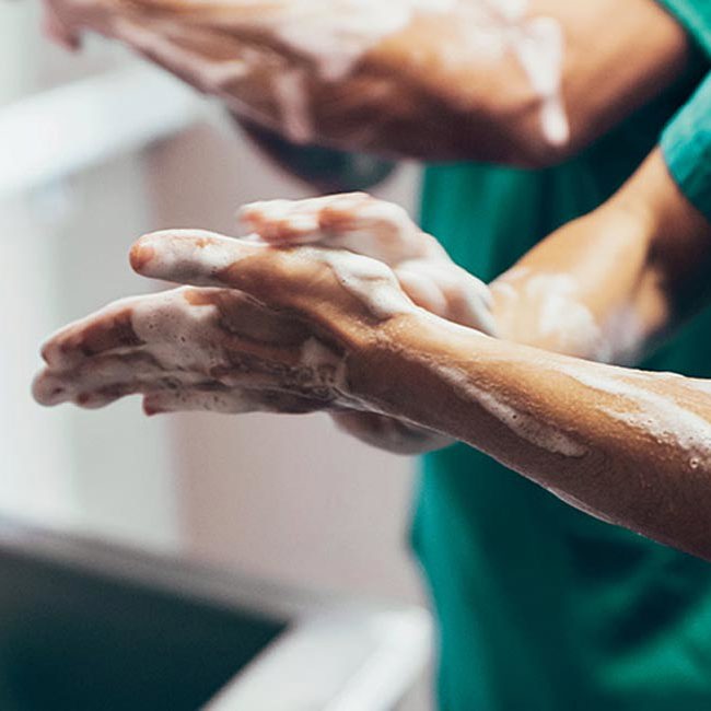 Læge vasker grundigt sine hænder inden operationen skal igang.