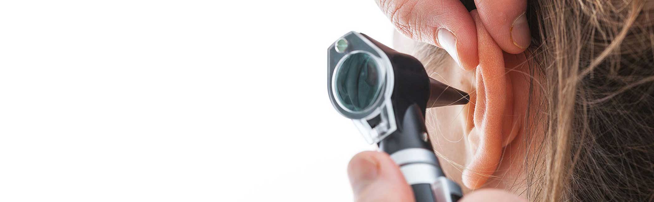 Læge tjekker patient efter hul på trommehinden.