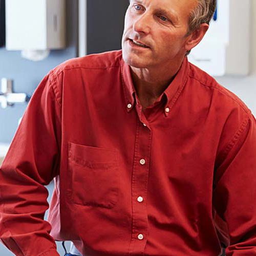 Kvindelig læge sidder med mandelig patient.