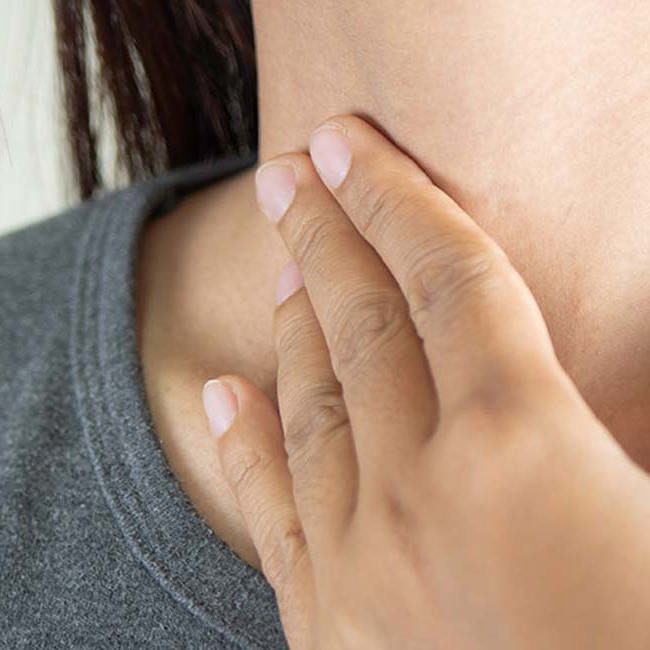 En kvinde har ondt i sine mandler i halsen.