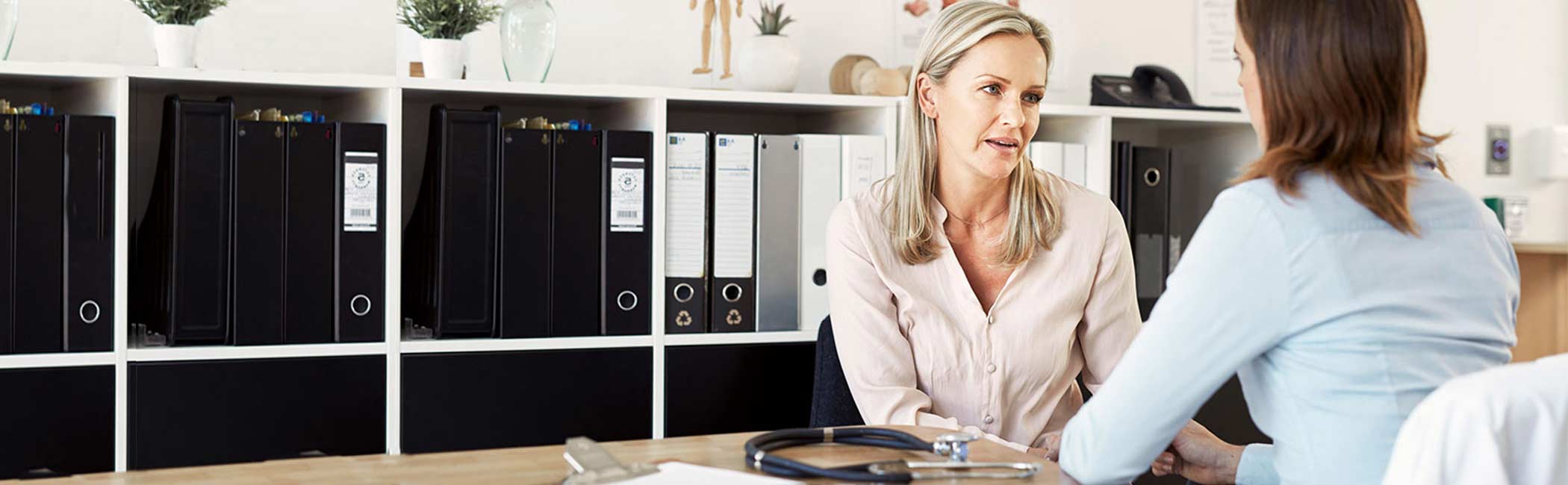 En kvinde og en øre, næse og halslæge sidder under konsultation.