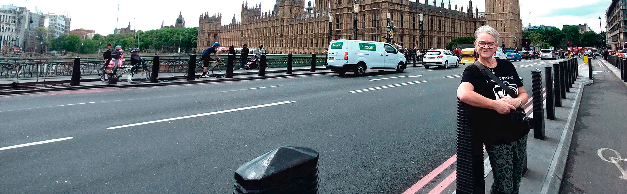 Kvinde står på gaden og smiler.