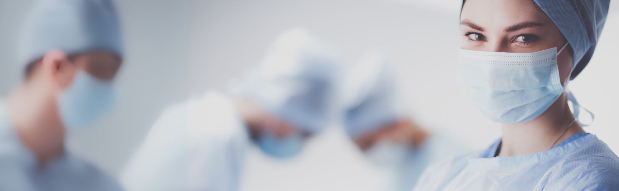 Kvindelig læge står i operationstøj.