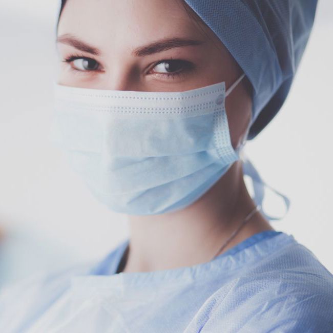 Kvindelig læge står i operationstøj.