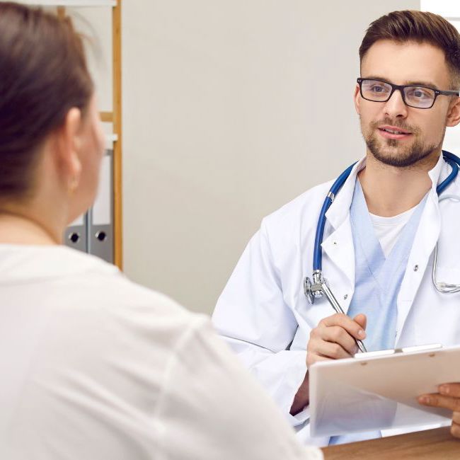 Overvægtig kvinde sidder til en konsultation hos lægen.