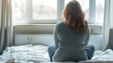 Kvinde kigger ud af vinduet.