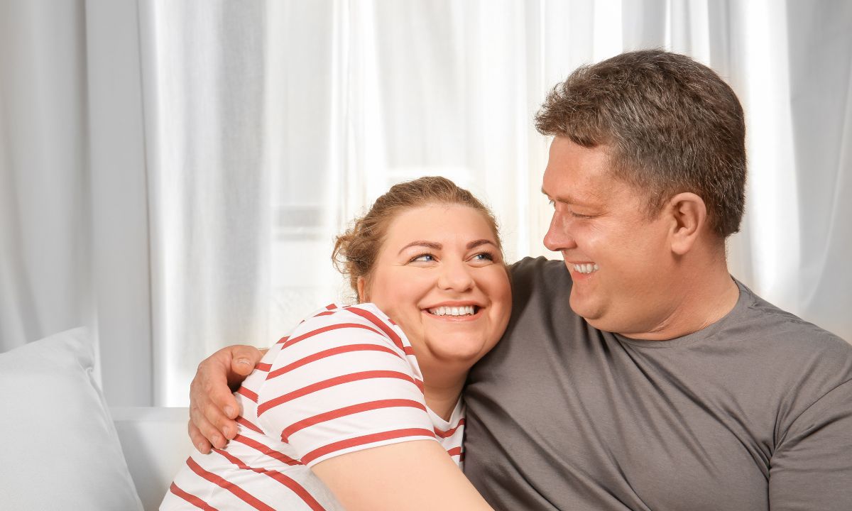 Et glad par krammer i sofaen.