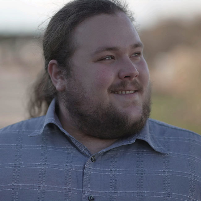 Overvægtig mand går og smiler.