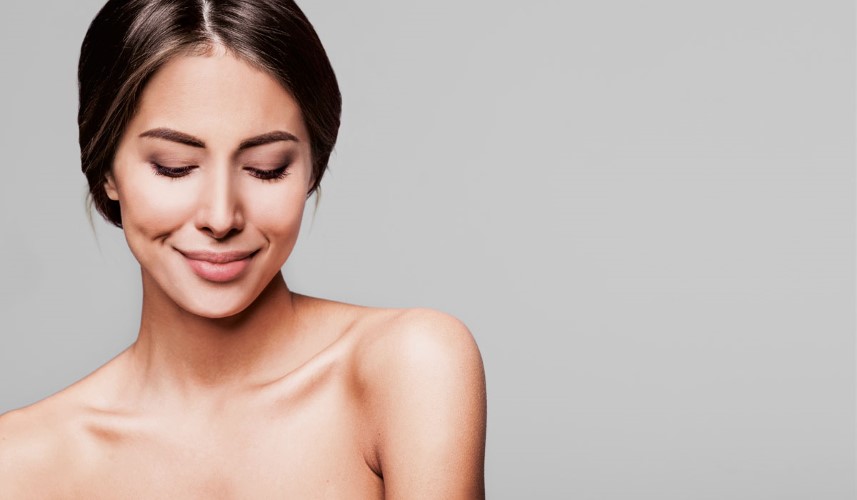 En kvinde kigger smilende ned på jorden.