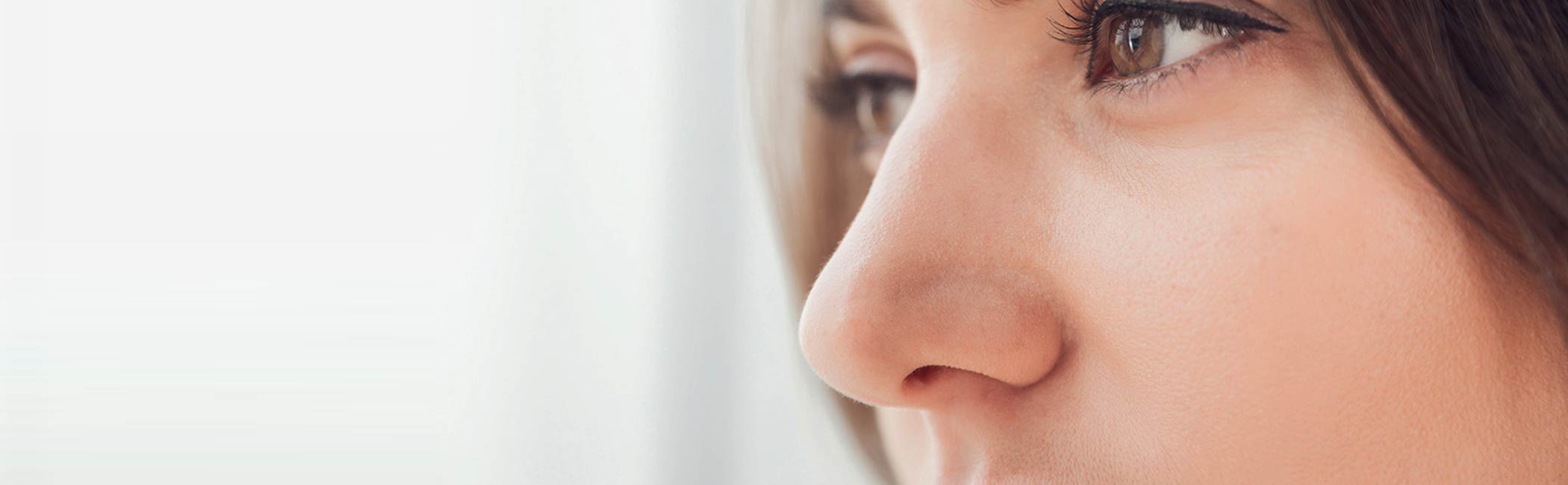 En kvinde kigger tænkende ud af et vindue.