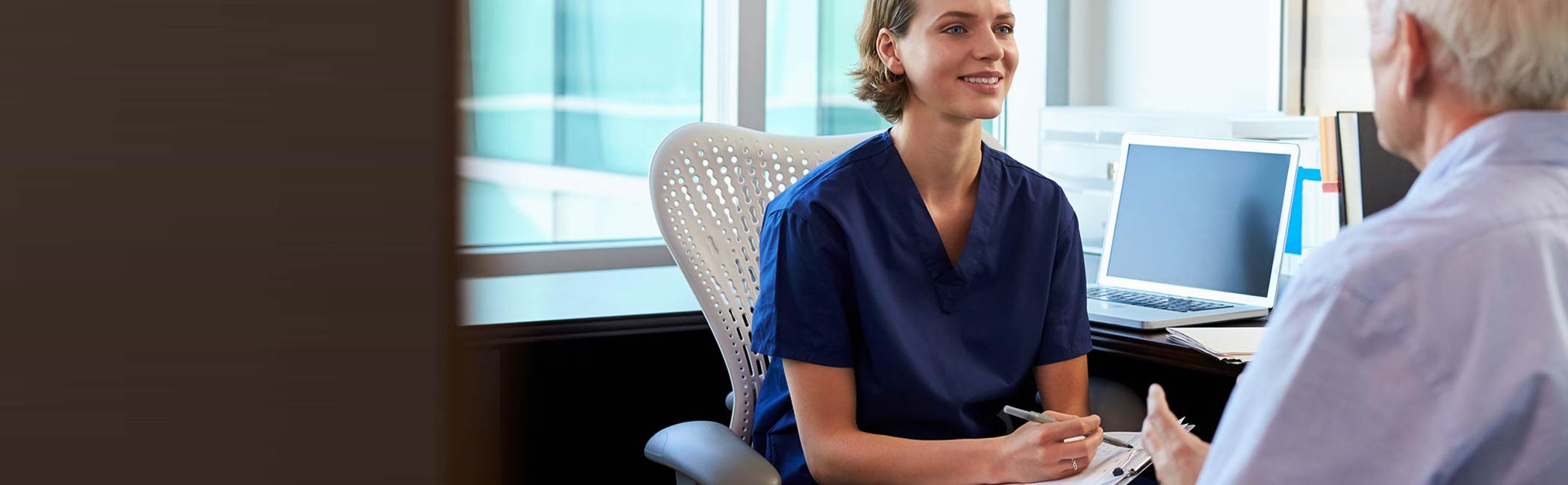 Reumatolog og patient sidder og snakker.