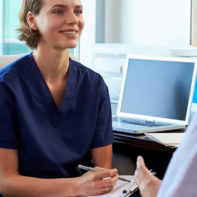 Reumatolog og patient sidder og snakker.