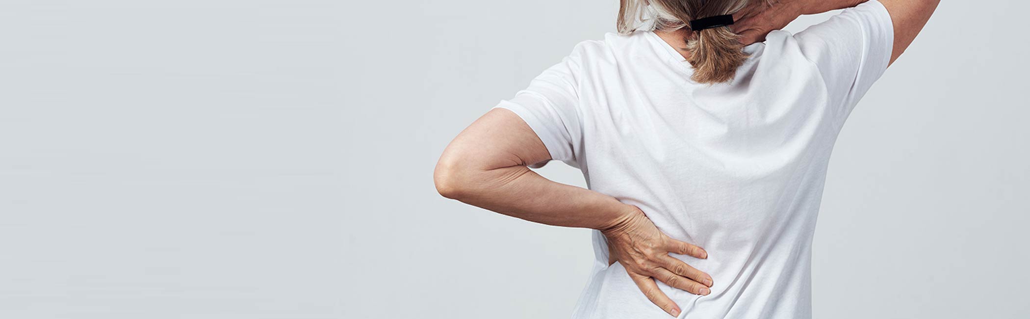 Kvinde strækker sig efter øvelser til at forbedre sin slidgigt.