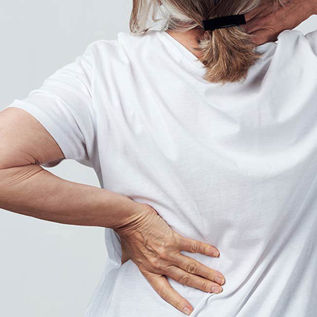 Kvinde strækker sig efter øvelser til at forbedre sin slidgigt.