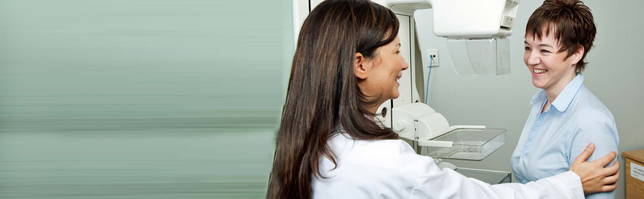 Smilende læge og patient fører en samtale.