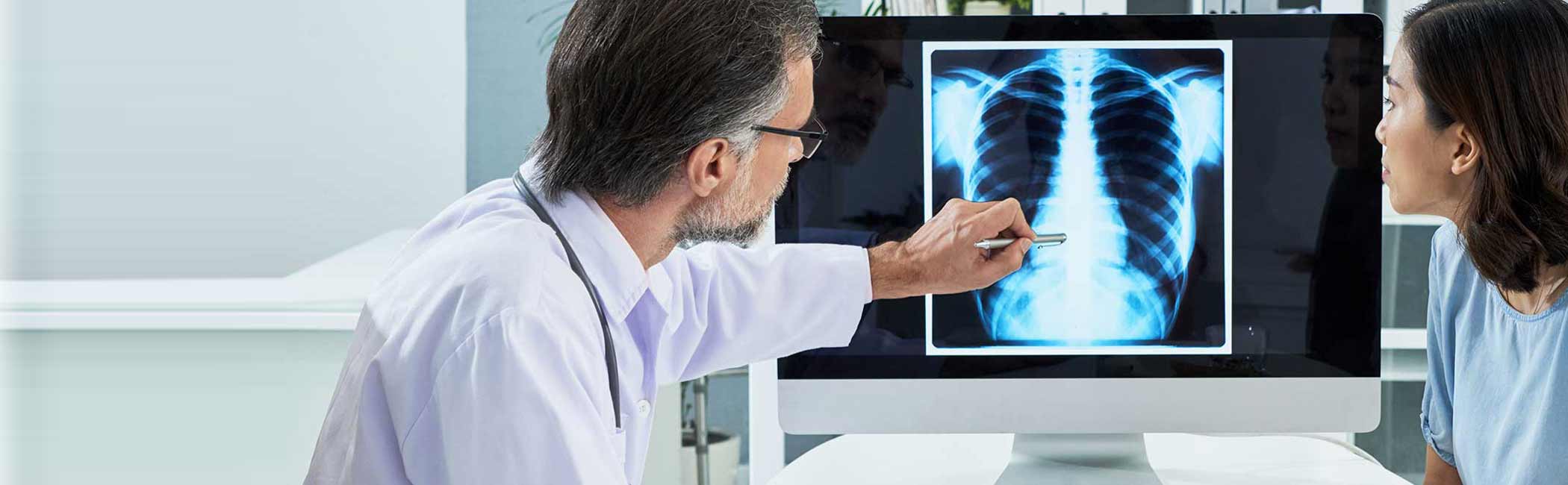 radiolog forklarer røntgenbillede af brystkasse.