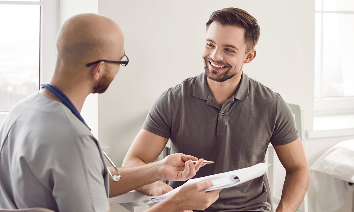 Læge taler med patient ved en konsultation.