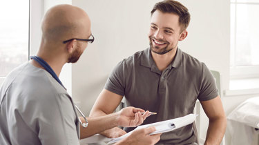 Læge taler med patient ved en konsultation.