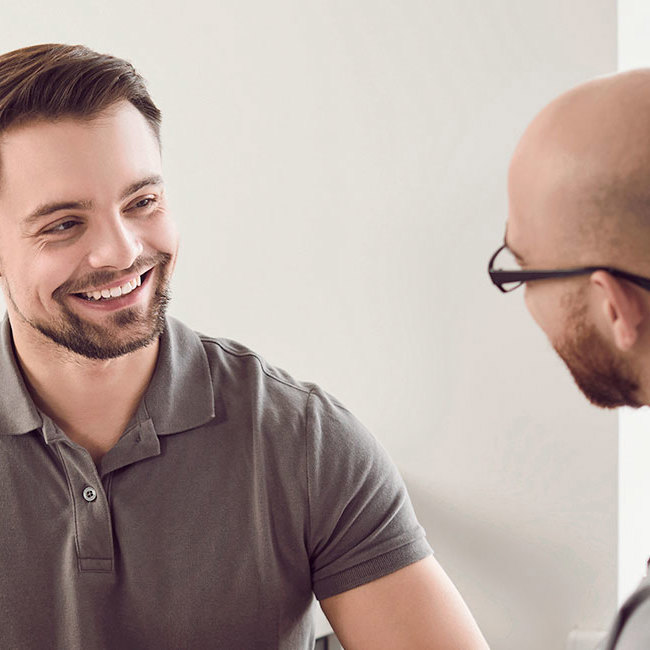 Læge taler med patient ved en konsultation.