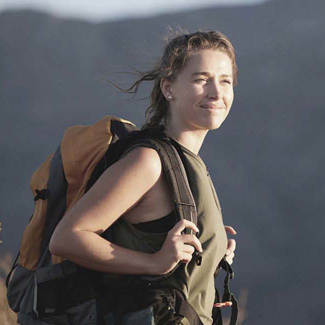 En glad kvinde er trygt ude og rejse efter at have fået relevante rejsevaccinationer.