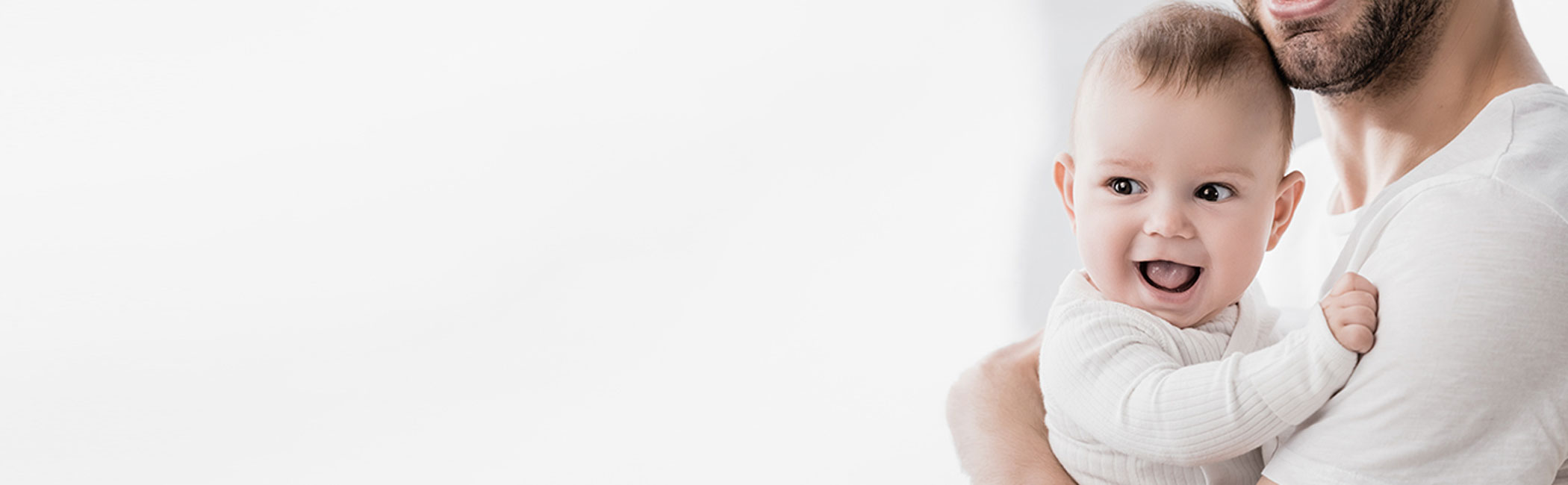 En smilende baby i armene på sin far.